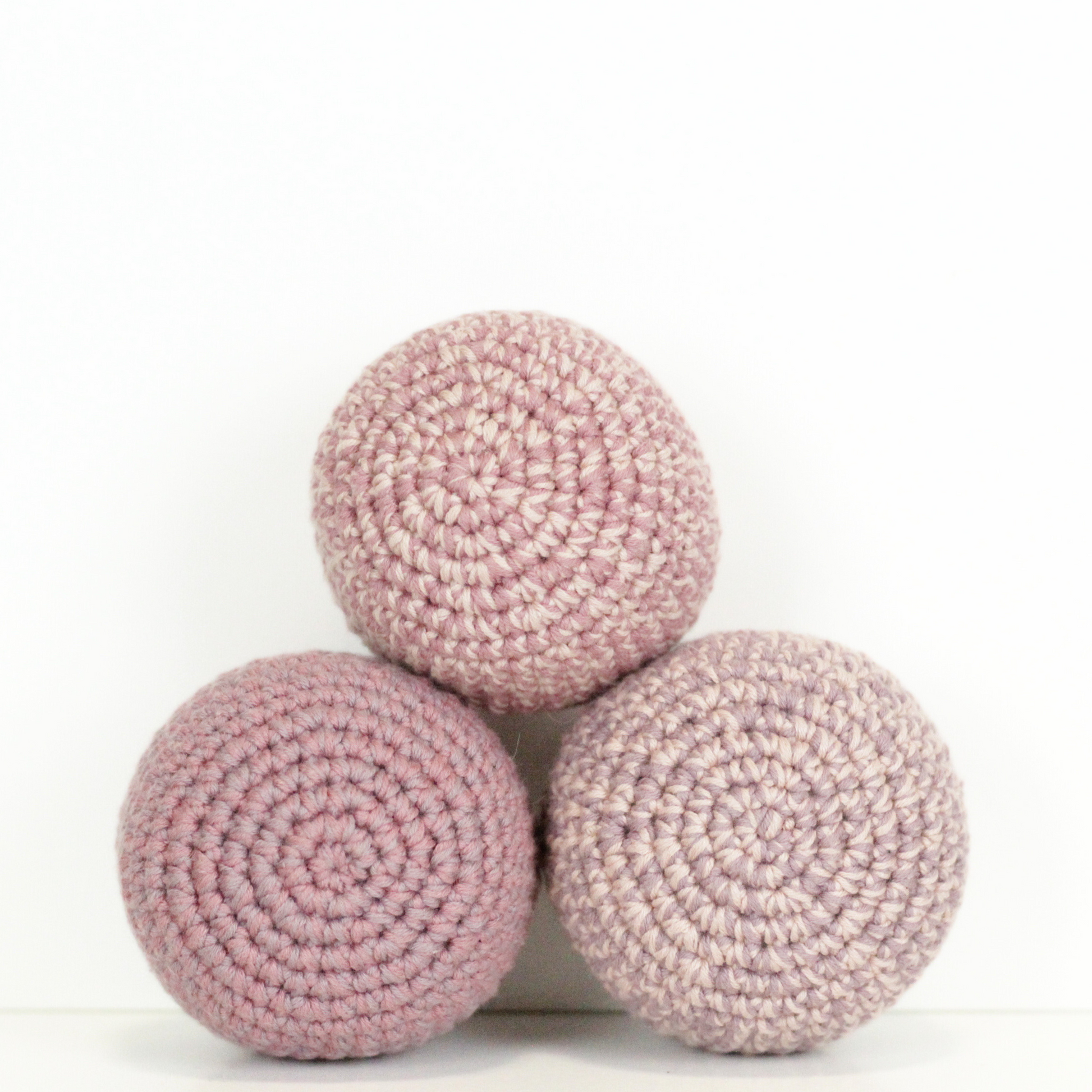 Three pink crochet balls stacked. Handmade crochet dog toys from Lana Royals Pet Wear.