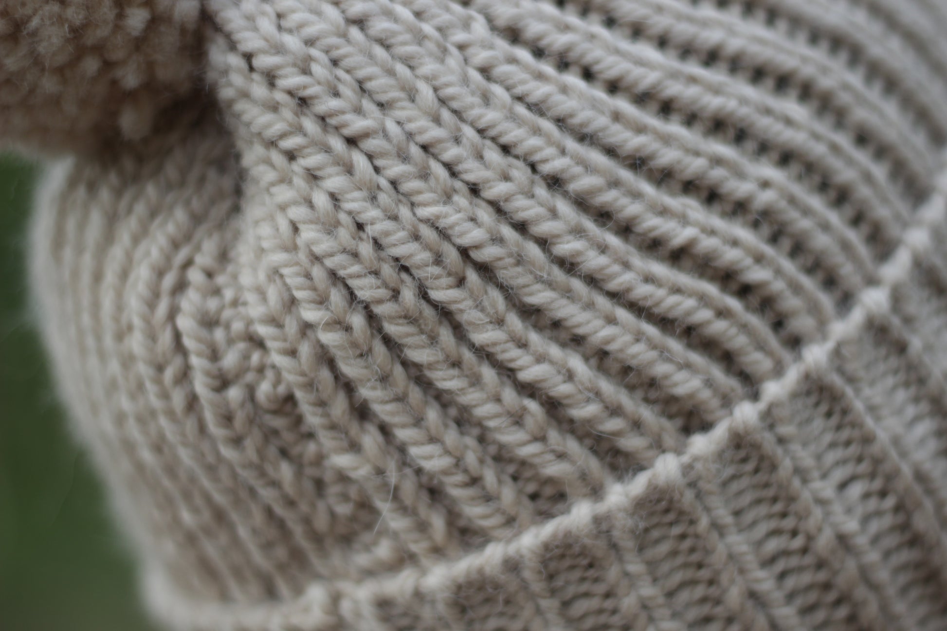 Close-up of beige alpaca wool knitted fabric with a textured ribber pattern. Handmade by Lana Royals Pet Wear Store.